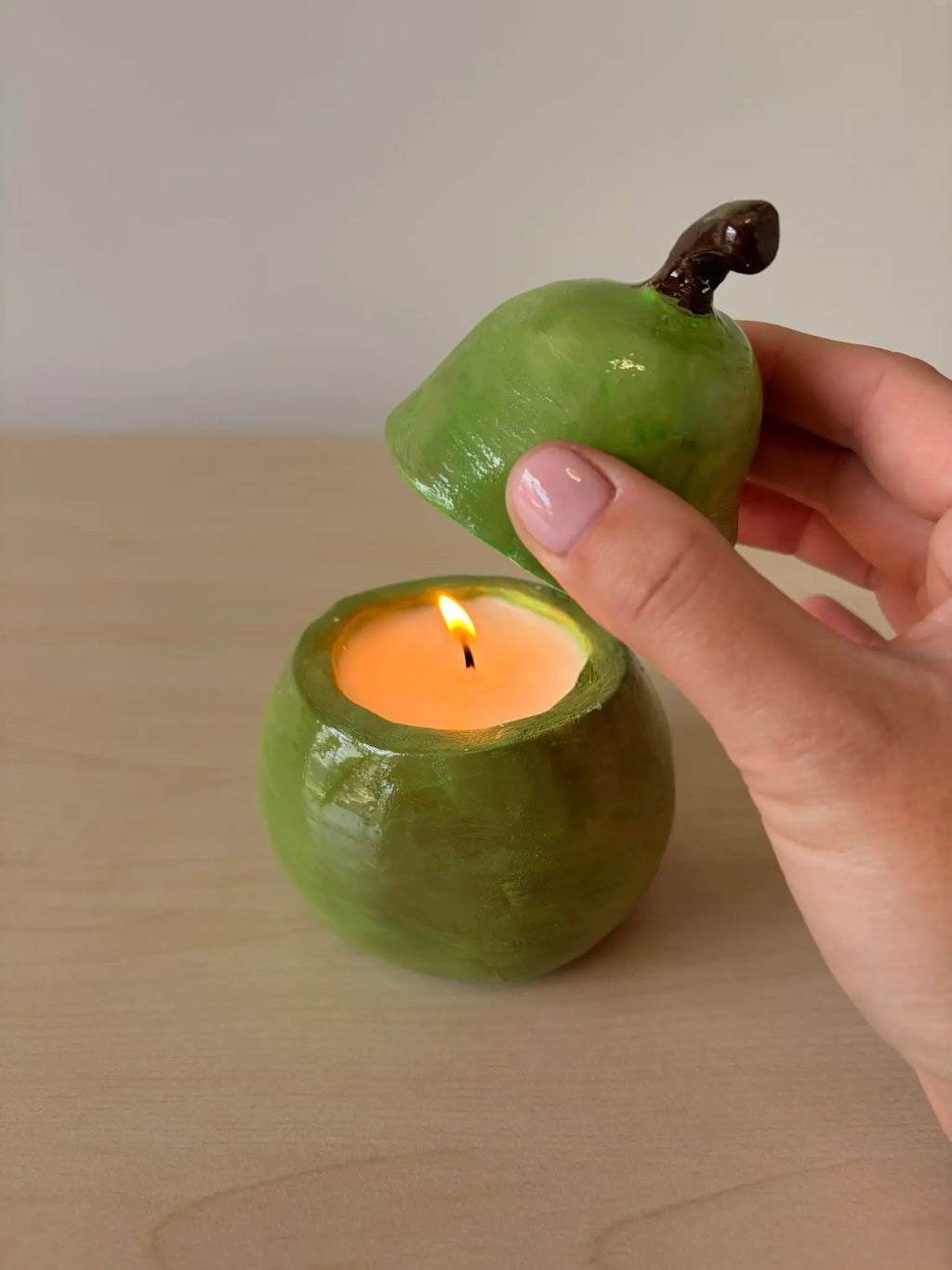 Handmade candle in a pear-shaped clay holder