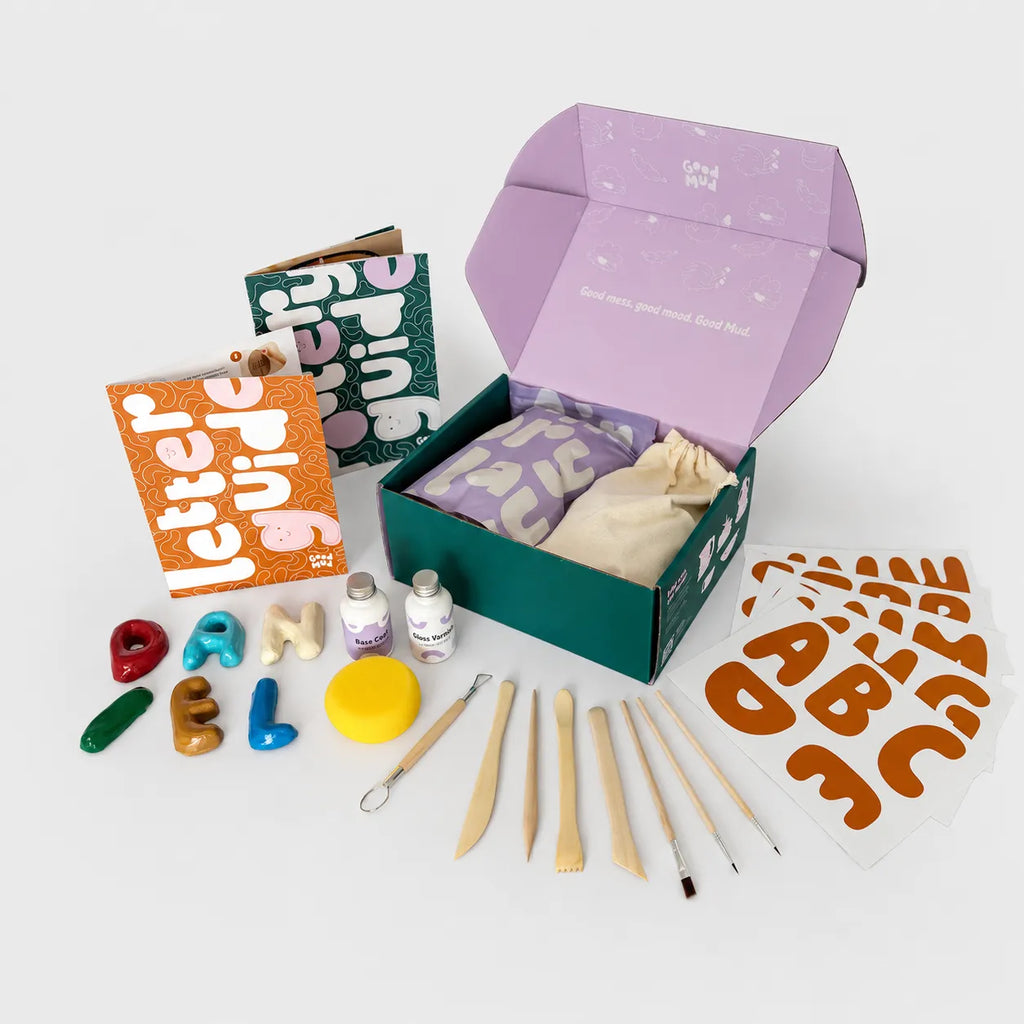 Contents of Good Mud letter kit with clay letters, stencils, tools and letter guide