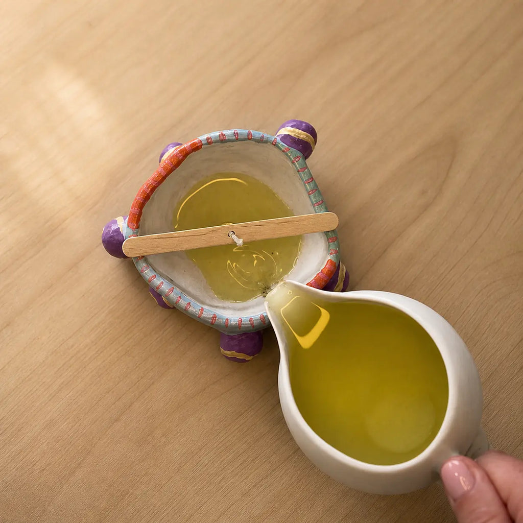 Pouring wax into a handmade clay candle holder