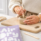 Person shaping clay using a DIY pottery kit
